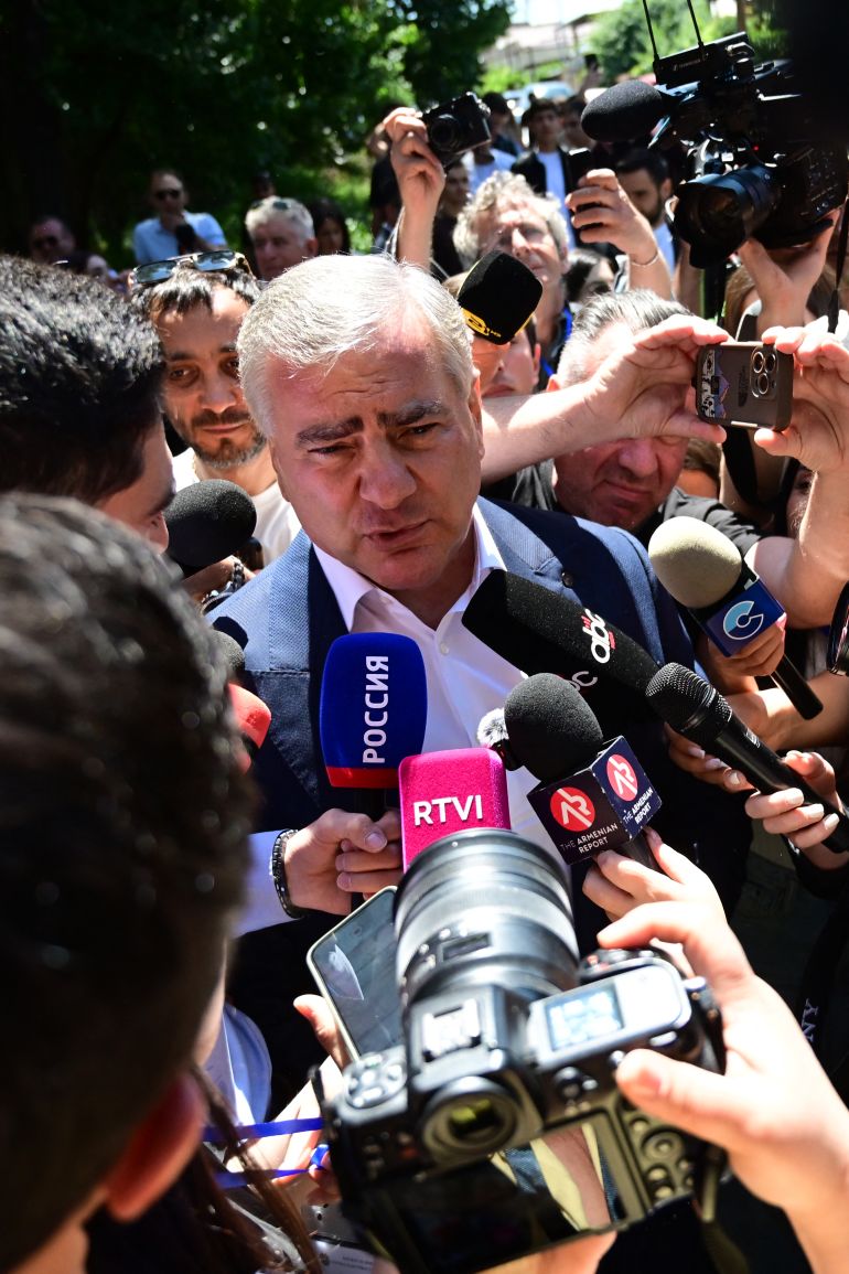 afp_6a2718758ff8-1780947061 Billionaire Russian-Armenian businessman Samvel Karapetyan, the leader of Strong Armenia party who is under house arrest on charges of plotting a coup, talks to the media outside a polling station after voting in Armenia's parliamentary election in Yerevan on June 7, 2026. (Photo by Karen MINASYAN / AFP)