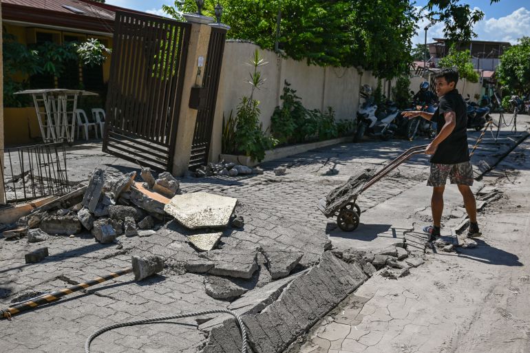 afp_6a2806857aca-1781008005 A man cleans up the debris from a damaged house after a 7.8 magnitude earthquake in General Santos City on June 9, 2026.