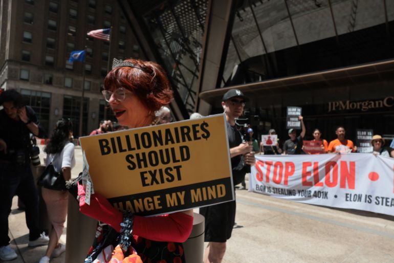 afp_6a2d0924f3ca-1781336357 NEW YORK, NEW YORK - JUNE 12: Protesters gather outside of JP Morgan's New York Headquarters on June 12, 2026 in New York City. Protesters demonstrated against Elon Musk and his extensive wealth following the launch of the SpaceX initial public offering (IPO) on the Nasdaq. The protest took place outside of the bank that helped to finance the historic IPO which has made Elon Musk, the founder, CEO, and Chief Engineer of SpaceX (Space Exploration Technologies Corp.), the world’s first trillionaire. Protesters demanded more equality and an end to financial policies that favor the rich. SpaceX closed just above $161 per share, up more than 19 percent from its I.P.O. price. Spencer Platt/Getty Images/AFP (Photo by SPENCER PLATT / GETTY IMAGES NORTH AMERICA / Getty Images via AFP)