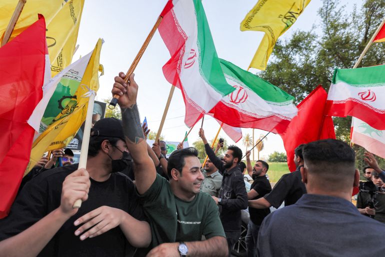 afp_6a305beee6b0-1781554158 People gather waving flags of Iran, Lebanon, and others near the Iranian embassy headquarters in Baghdad on June 15, 2026, during celebrations following the announcement of a deal to end the war between Iran and the US.