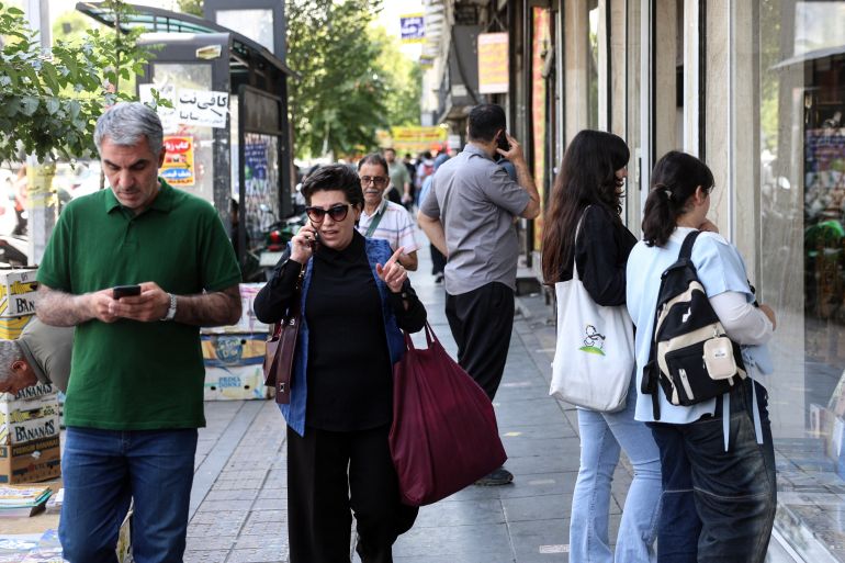 afp_6a33e0deb3b6-1781784798 Iranians walk through a street in Tehran on June 18, 2026.
