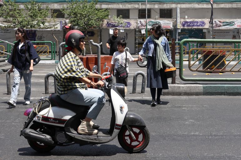 afp_6a33e16c849f-1781784940 An Iranian woman rides a scooter through a street of Tehran on June 18, 2026.