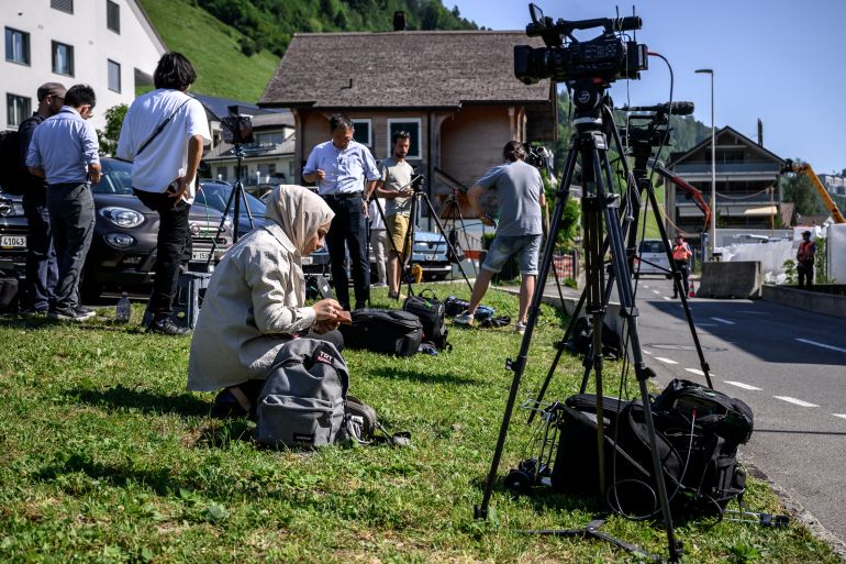 TOPSHOT - Journalists set up near an access to the Burgenstock luxury hotel complex above Lake Lucerne, where talks following up on a deal to end the Middle East conflict were scheduled to begin, on June 19, 2026.