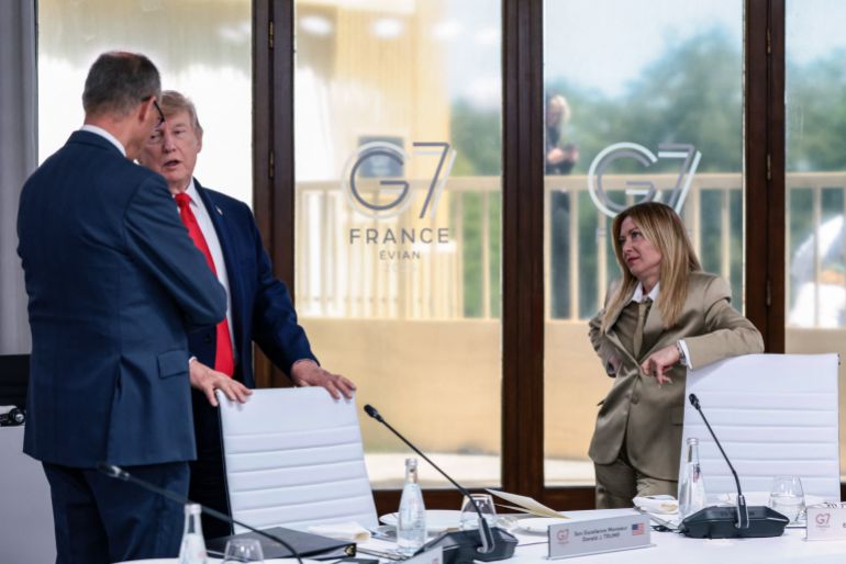 TOPSHOT - US President Donald Trump speaks with Germany's Chancellor Friedrich Merz next to Italy's Prime Minister Giorgia Meloni during a work lunch as part of the G7 summit, in Evian, eastern France, on June 16, 2026.