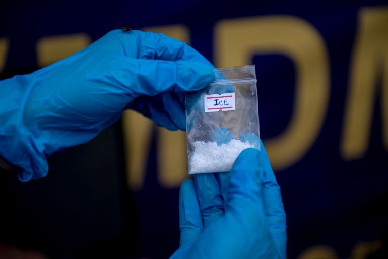 An official shows a bag of methamphetamine before seized illegal drugs are set on fire during a destruction ceremony to mark the United Nations' "International Day against Drug Abuse and Illicit Trafficking" in Yangon on June 26, 2026. (Photo by Sai Aung MAIN / AFP)