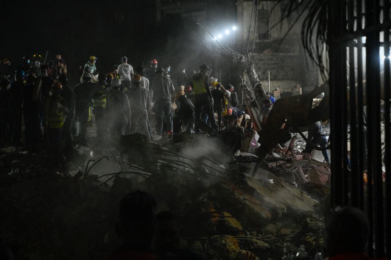 TOPSHOT - Rescue workers and volunteers search through the rubble of a collapsed building in Caracas on June 25, 2026, following a series of earthquakes.