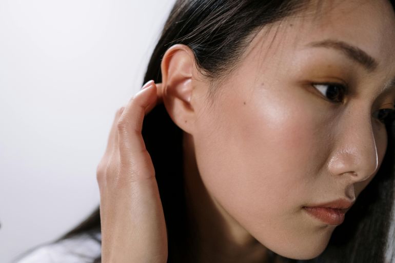 A close-up portrait focusing on a woman's face and clear skin tone.