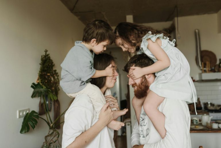 A cheerful family enjoying playful bonding time together in a cozy home setting.