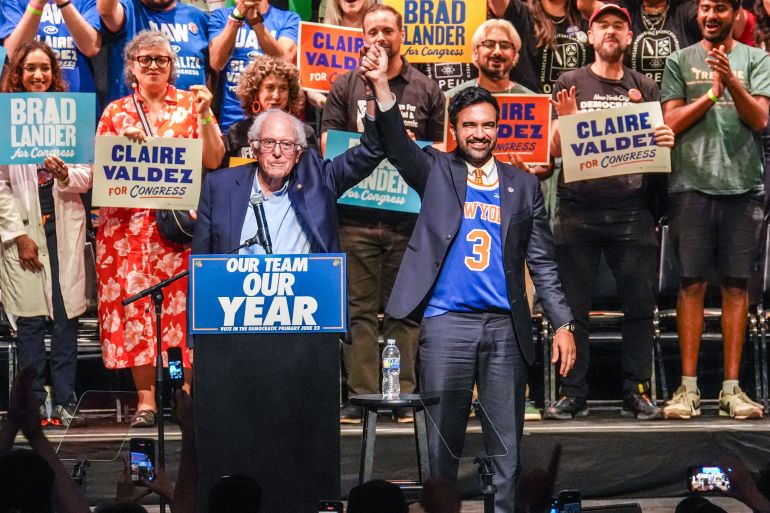 ap26170035544438-1782030770 Mayor Zohran Mamdani, right, gestures on stage with U.S. Sen. Bernie Sanders, I-VT., during a Get Out The Vote rally ahead of New York's primary election, Thursday, June 18, 2026, in the Brooklyn borough of New York. (AP Photo/Ryan Murphy)