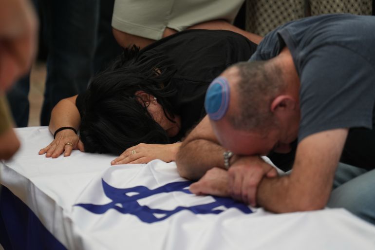Hilit Yanai, left, mourns over the coffin of her daughter, Israeli soldier Sgt. Rotem Yanai, who was killed in a Lebanese drone attack in northern Israel, during her funeral in Givat Ada, Israel, Thursday, May 28, 2026. (AP Photo/Ariel Schalit)