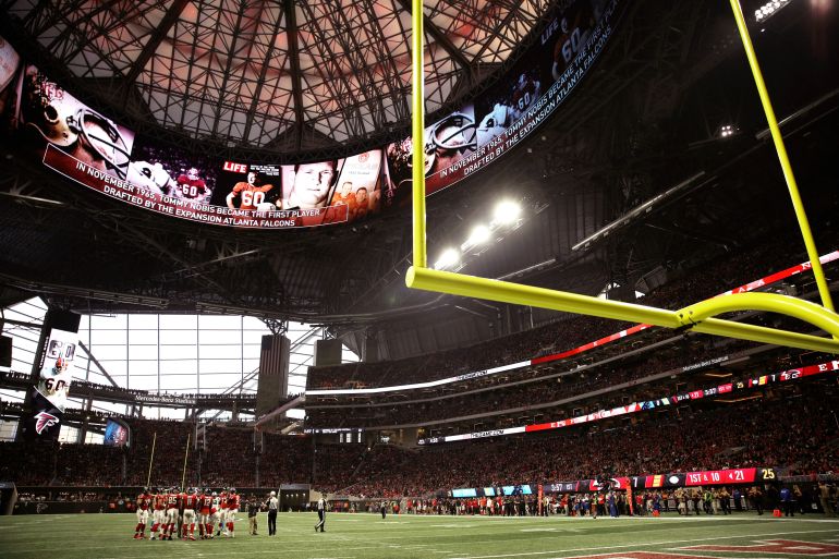 FILE - In this Dec. 31, 2017, file photo, the Atlanta Falcons and Carolina Panthers huddle during the first half of an NFL football game, in Atlanta. Atlanta’s new $1.5 billion stadium is about to be on perhaps its largest national stage for the Monday, Jan. 8, 2018, College Football Playoff title game, fans say the glitzy facility is living up to the hype despite a series of construction setbacks that delayed its opening. (AP Photo/David Goldman, File)