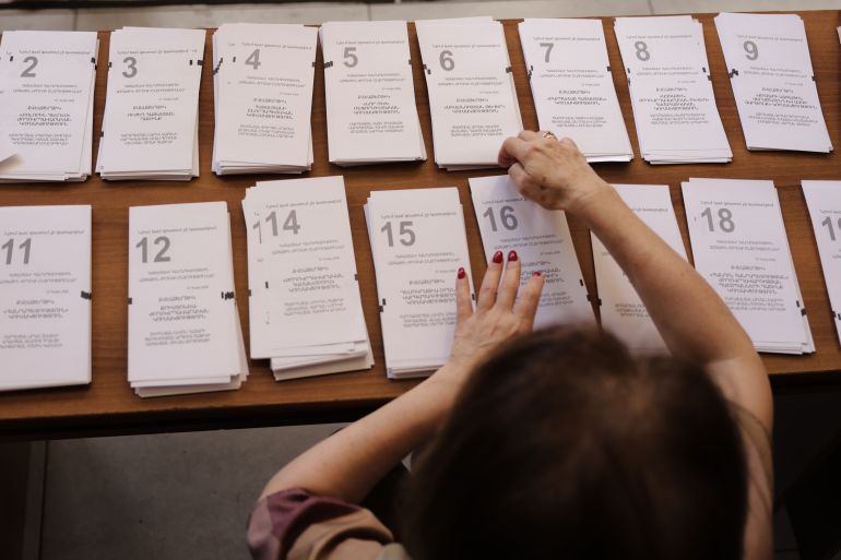 ap_6a2679d9751c0-1780906457 A member of an election commission prepares the ballots while waiting for voters at a polling station, during a parliamentary election in Yerevan, Armenia, Sunday, June 7, 2026. (AP Photo/Anthony Pizzoferrato)