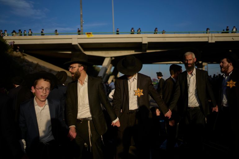 Ultra-Orthodox Jewish men block a main road during a protest against military recruitment near Tel Aviv, Israel, Thursday, June 11, 2026. (AP Photo/Ohad Zwigenberg)