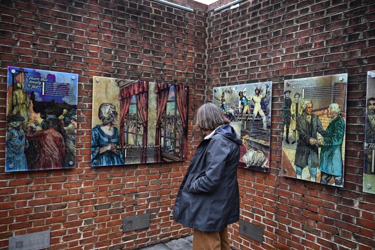 ap_6a339dfad0a83-1781767674 FILE - A person views panels that were part of an exhibit on slavery at the President's House Site in Philadelphia after they are put back Thursday, Feb. 19, 2026. (AP Photo/Joe Lamberti, File)