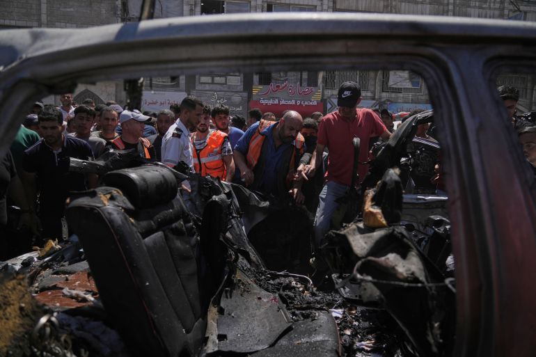 ap_6a35223378be8-1781867059 Palestinians gather around a car hit in an Israeli strike in Gaza City, Thursday, June 18, 2026. (AP Photo/Jehad Alshrafi)