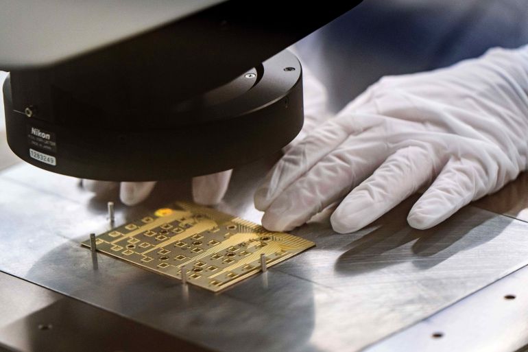 ap_6a38f4c2e5fc0-1782117570 A gowned worker adjusts a test coupon for indium phosphide wafer certification testing in a Coherent manufacturing facility where lasers are developed for transmitting data among chips, which could decrease power use by AI systems, on Tuesday, June 16, 2026, in Sherman, Texas. Jensen Huang, president and CEO of Nvidia was at the facility with Coherent CEO Jim Anderson to break ground on an expansion of the building. (AP Photo/Jeffrey McWhorter)