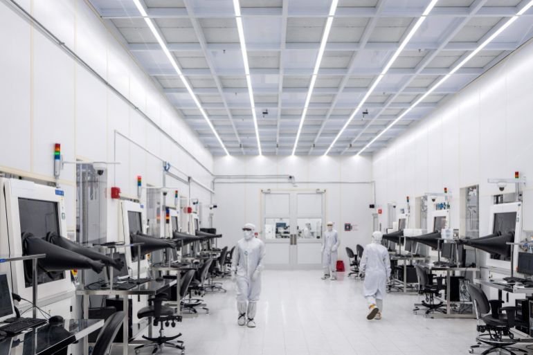 ap_6a390b4e27f59-1782123342 Coherent employees Samuel Aninkora, Matthew Thomason, and Alyssa McKee, left to right, work in a clean room at a Coherent manufacturing facility where lasers are developed for transmitting data among chips, on Tuesday, June 16, 2026, in Sherman, Texas. Jensen Huang, president and CEO of Nvidia was at the facility with Coherent CEO Jim Anderson to break ground on an expansion of the building. (AP Photo/Jeffrey McWhorter)