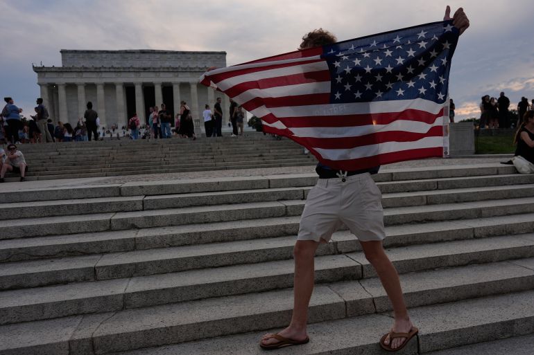 A person holds up an American flag at the Lincoln Memorial Thursday, June 25, 2026, in Washington. (AP Photo/Carolyn Kaster)