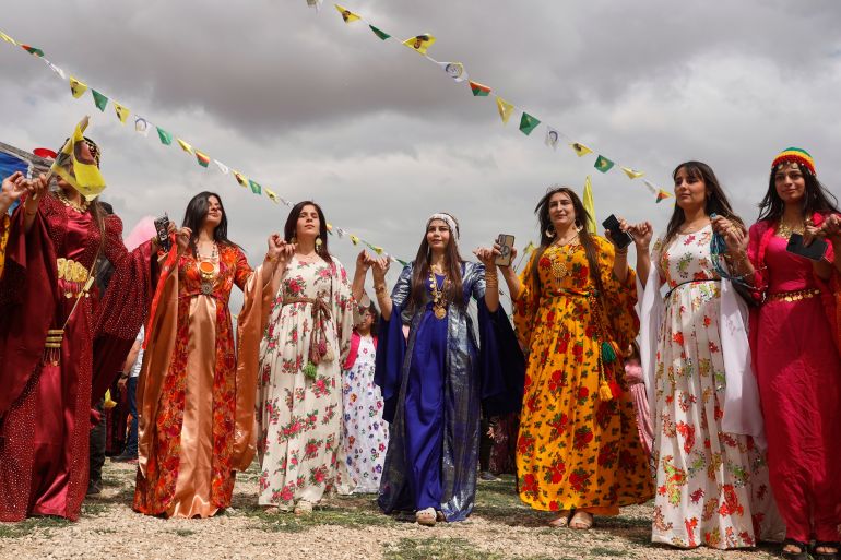 Syrian Kurdish women, wearing traditional clothing, dance as they gather to celebrate their Nowruz, Kurdish New Year, in Qamishli, northeastern Syria, Friday March 21, 2025. (AP Photo/Baderkhan Ahmad)