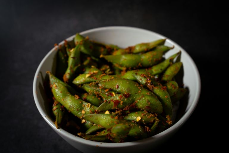 Close-up of spicy edamame beans in a bowl, showcasing vibrant flavors and textures.