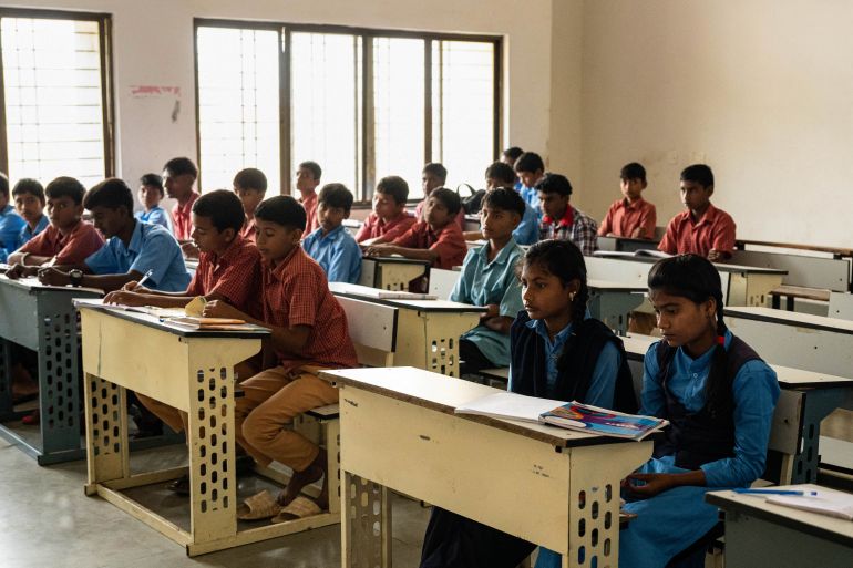 In this photograph taken on September 27, 2025, children attend a class at the government-run Netaji Subhas Chandra Bose residential school that houses tribal students from drought-ridden villages, at Toranmal in Nandurbar district. In the villages of Maharashtra's Nashik and Nandurbar districts, wells are drying up and rainfall has become increasingly erratic, forcing families to adapt to harsher living conditions. As men migrate to nearby cities in search of work, girls are left to take on the responsibility of collecting water. A 2021 UNESCO report warned that climate-related disruptions could push millions of girls worldwide out of classrooms. (Photo by Shefali RAFIQ / AFP) / TO GO WITH 'INDIA-ENVIRONMENT-WATER-EDUCATION', REPORTAGE