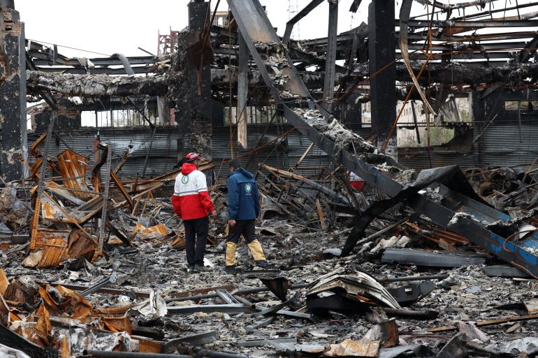 epa12856216 Members the Iranian Red Crescent stand amid the wreckage of vehicles at an auto service centre in Tehran, Iran, 28 March 2026. A joint Israeli and US military operation continues to target multiple locations across Iran since the early hours of 28 February 2026. EPA/ABEDIN TAHERKENAREH