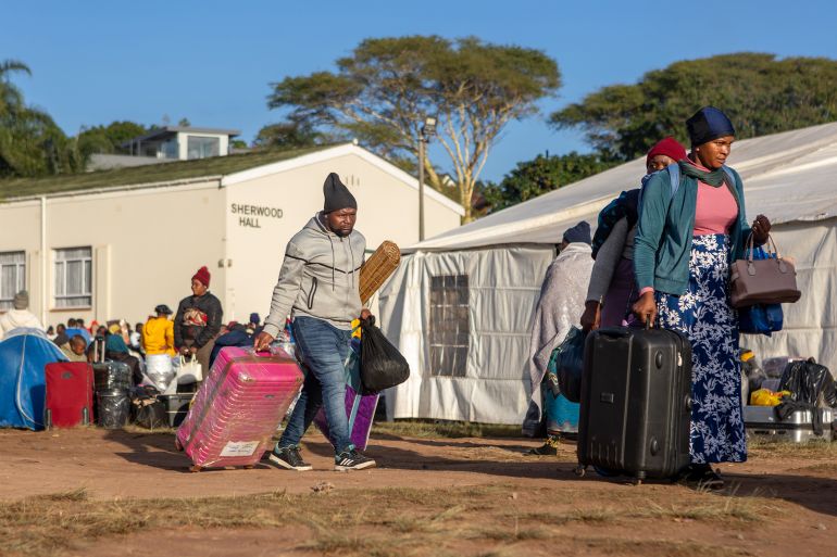 epa13028690 Malawi migrants to South Africa carry their luggage in an informal refugee camp in Sherwood, Durban, South Africa, 10 June 2026. Fearing xenophobic attacks, over 1,000 immigrants, mostly from Malawi, have fled their shacks in Burnwood and seek refuge here after South African residents told them to leave on 07 June. EPA/STRINGER