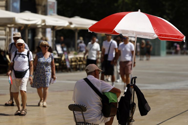 epa_6a36b8cf9144-1781971151 epa13046578 A man sits under a sun shade on a sunny day in Montpellier, southern France, 18 June 2026. France is experiencing rising temperatures, prompting Meteo-France to issue an orange warning for 29 departments. EPA/GUILLAUME HORCAJUELO