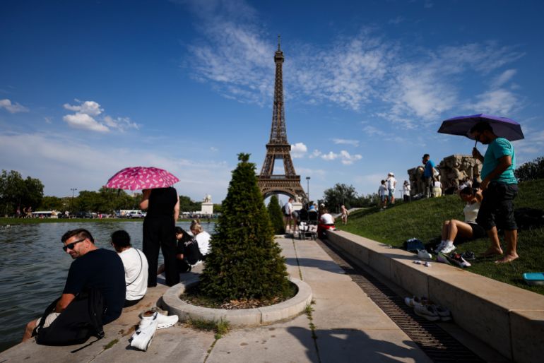 epa_6a3779ee8594-1782020590 epa13052300 People shelter from the heat under umbrellas at the Trocadero Fountain by the Eiffel Tower, in Paris, France, 20 June 2026. An intense heatwave is gripping Western and Central Europe, pushing temperatures far above seasonal norms for mid-June. EPA/YOAN VALAT