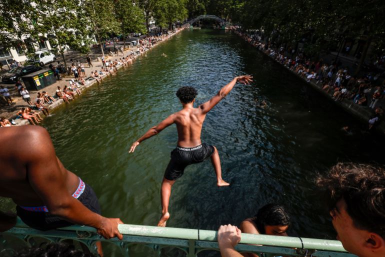 epa_6a378125811f-1782022437 epa13052276 A young man jumps from a bridge to cool off in the Canal Saint-Martin, in Paris, France, 20 June 2026. An intense heatwave is gripping Western and Central Europe, pushing temperatures far above seasonal norms for mid-June. EPA/YOAN VALAT