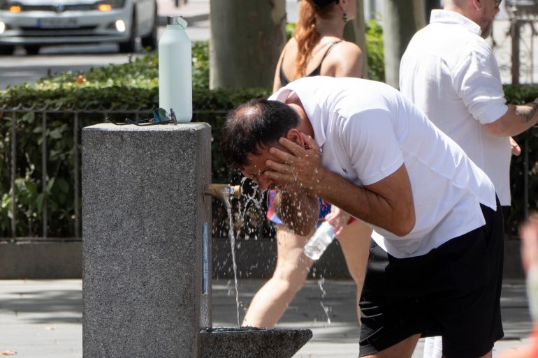 epa13053883 A man cools off in a fountain in Seville, Andalusia, Spain, 21 June 2026, as the first heatwave of the season brings temperatures above 39 to 40 degrees across much of the Iberian Peninsula and the Balearic Islands, with a risk of very severe thunderstorms in Galicia and Asturias and an 'extraordinary danger' warning in parts of the Basque Country. EPA/DAVID ARJONA
