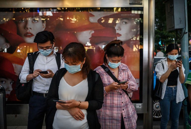 getty_6a1d7b3290-1780316978 BEIJING, CHINA - SEPTEMBER 21: Chinese commuters look at their mobile phones as they wait at a bus stop on September 21, 2020 in Beijing, China. A U.S. federal judge has issued an injunction against President Donald Trump's executive order to ban the popular Chinese mobile app We Chat from U.S. app stores as of midnight on Sunday. The action is seen as an escalation between the two countries regarding tech issues and the order would also prevent U.S. companies from processing transactions made via the app. (Photo by Kevin Frayer/Getty Images)