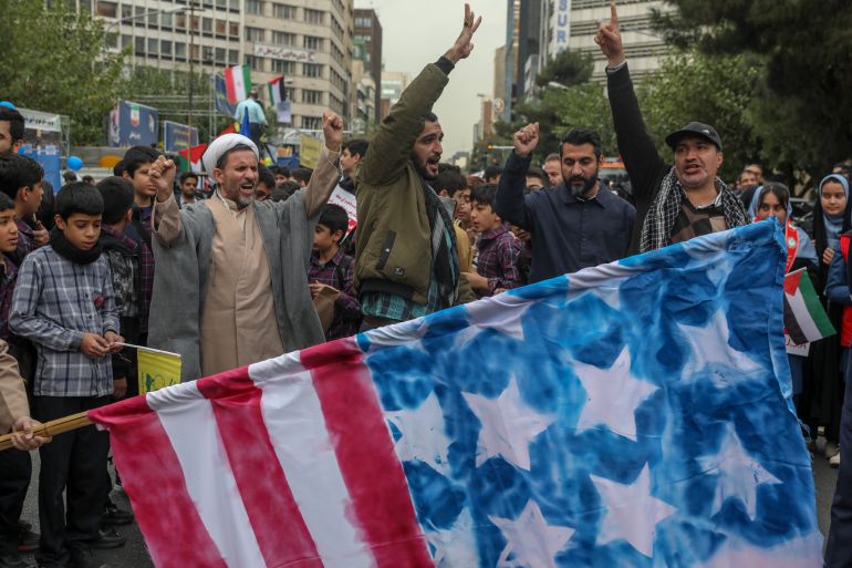 TEHRAN, IRAN - NOVEMBER 3: People burn a US and Israeli flag during a rally outside the former US embassy in Tehran as Iranians mark the 45th anniversary of the start of the Iran hostage crisis, on November 3, 2024 in Tehran, Iran. In November 1979, Iranian students seized the US embassy here and took captive fifty-two embassy staff, demanding that Washington hand over Iran's recently toppled shah, who was being treated in the United States for cancer. The hostage crisis lasted 444 days. (Photo by Majid Saeedi/Getty Images)