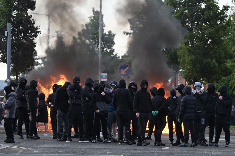 getty_6a290e5615-1781075542 BELFAST, NORTHERN IRELAND - JUNE 9: Youths gather infront of a burning barricade on Duncairn Gardens on June 9, 2026 in Belfast, Northern Ireland. Demonstrations have been called in reaction to what police described as a "brutal" knife attack in north Belfast on Monday night, which has left a male victim in his 40's with serious injuries. The Home Office has confirmed the suspected knifeman is a Sudanese national who was in the UK on leave to remain, after being granted refugee status in 2023. Officials have called for calm as misinformation circulated online following the attack. (Photo by Charles McQuillan/Getty Images)