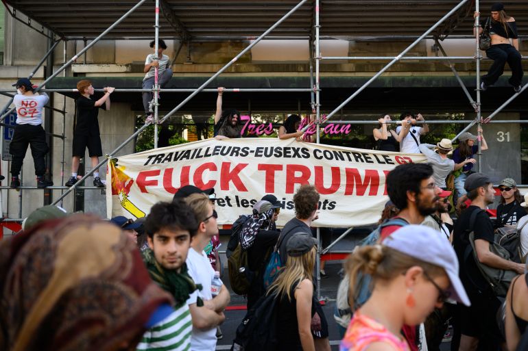 getty_6a2f9d6915-1781505385 GENEVA, SWITZERLAND - JUNE 14: (EDITOR'S NOTE: Image contains profanity) Protesters install a banner against Trump during a protest ahead of the G7 Summit on June 14, 2026 in Geneva, Switzerland. This week's G7 summit will take place from June 15-17 in nearby Evian-les-Bains, France, as leaders grapple with challenges to peace and security for Ukraine and Europe, the situation in the Middle East, and other geopolitical issues. (Photo by Harold Cunningham/Getty Images)