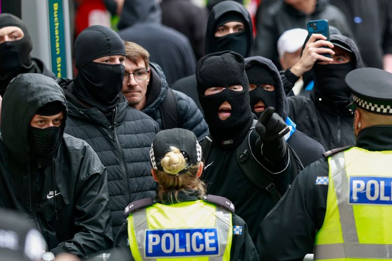 getty_6a37323684-1782002230 GLASGOW, SCOTLAND - JUNE 13: Anti immigration protesters attend the 'Glasgow Reclaims The Streets From Far-right Hatred And Violence' anti-racism protest on June 13, 2026 in Glasgow, Scotland. The recent racially motivated street assaults in Glasgow were fueled by widespread outrage over last week's stabbing in Belfast and the tragic murder of 18-year-old student Henry Nowak in Southampton. Nowak's killer, Vickrum Digwa, was convicted in late May 2026, national anger intensified when police bodycam footage revealed that responding officers mistakenly handcuffed and arrested a dying Nowak instead of assisting him, after Digwa falsely claimed he was the victim of a racial attack. This systemic failure, alongside the Belfast stabbing, has been leveraged by far-right figures to incite a mob of several hundred masked men to march under white nationalist slogans, leading to racially motivated street assaults and an attempted siege of the Glasgow Central Mosque. (Photo by Jeff J Mitchell/Getty Images)