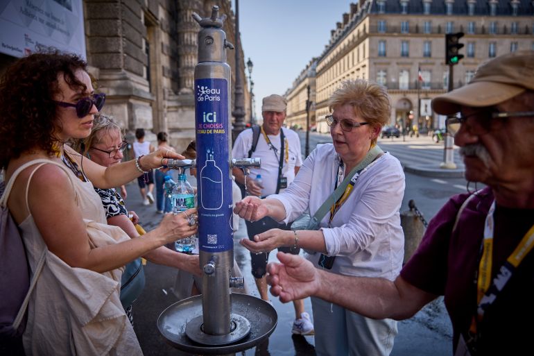PARIS, FRANCE - JULY 01: People use a public fountain on the Rue de Rivoli to cool off from the heat of the day as Paris experiences temperatures of up to 44°C on July 01, 2025 in Paris, France. The French weather agency Météo France has placed Paris and 15 other districts on the highest alert for heat risk, as a heatwave sweeps across France and other parts of Europe on Tuesday. The red alert was last issued for Paris in August 2023. (Photo by Kiran Ridley/Getty Images)