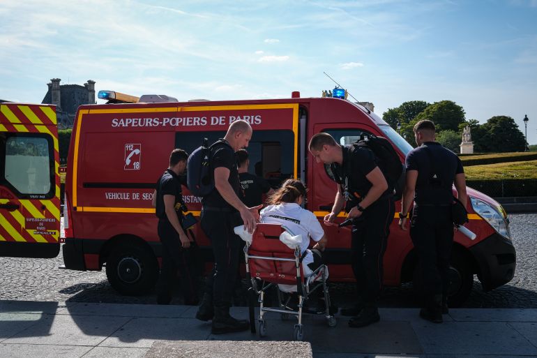 PARIS, FRANCE - JUNE 25: Firefighters from the Paris Fire Brigade assist a person into an ambulance after they became unwell during an intense heatwave on June 25, 2026 in Paris, France. Various European governments issued health warnings this week in relation to the high temperatures, which were nearing 40 degrees celsius in many large cities. (Photo by Annice Lyn/Getty Images)