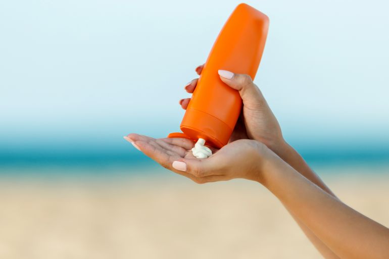 gettyimages-1047792178-1718116206 Woman hand apply sunscreen on the beach