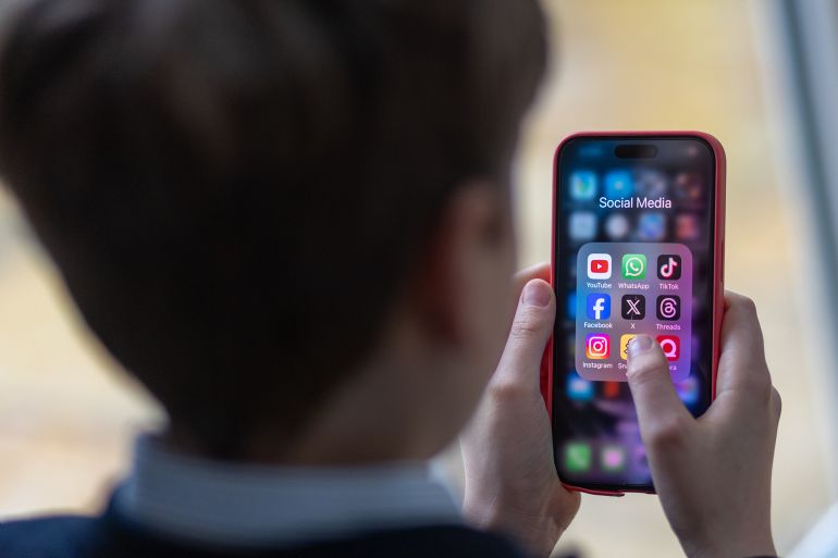 gettyimages-2038598683-1749229828 BATH, UNITED KINGDOM - FEBRUARY 25: In this photo illustration a a 12-year-old school boy looks at a iPhone screen A 12-year-old boy looks at an iPhone screen showing various social media apps including TikTok, Facebook and X on February 25, 2024 in Bath, England. This week the UK government issued new guidance backing headteachers in prohibiting the use of mobile phones throughout the school day, including at break times. Many schools around the country are already prohibiting mobile phone use over concerns. The amount of time children spend on screens each day rocketed during the Covid pandemic by more than 50 per cent, the equivalent of an extra hour and twenty minutes. Researchers say that unmoderated screen time can have long-lasting effects on a child's mental and physical health. Recently TikTok announced that every account belonging to a user below age 18 have a 60-minute daily screen time limit automatically set. (Photo by Matt Cardy/Getty Images)