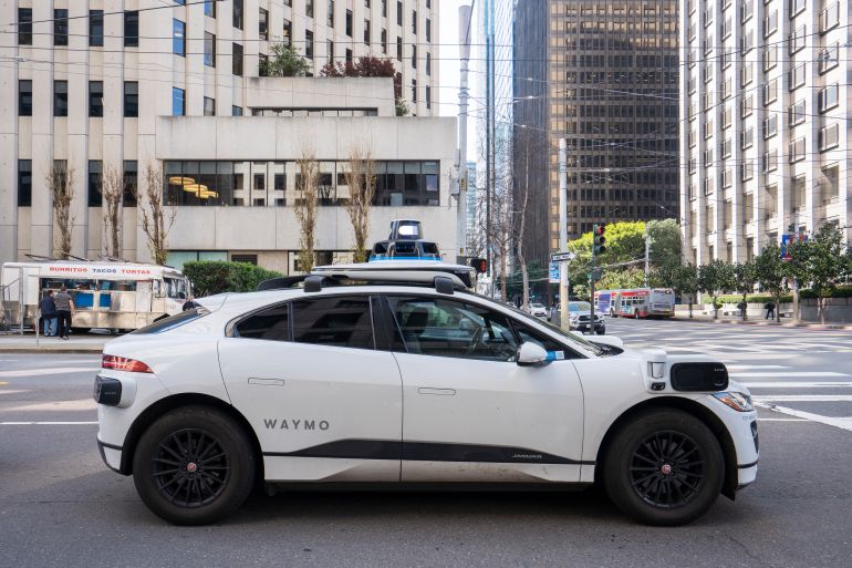 gettyimages-2214435963-1781280842 San Francisco, CA, USA - Feb 22, 2024: A Waymo all-electric robotaxi stops at a red light on the streets in the Financial District of San Francisco. Waymo One is an autonomous ride-hailing service.
