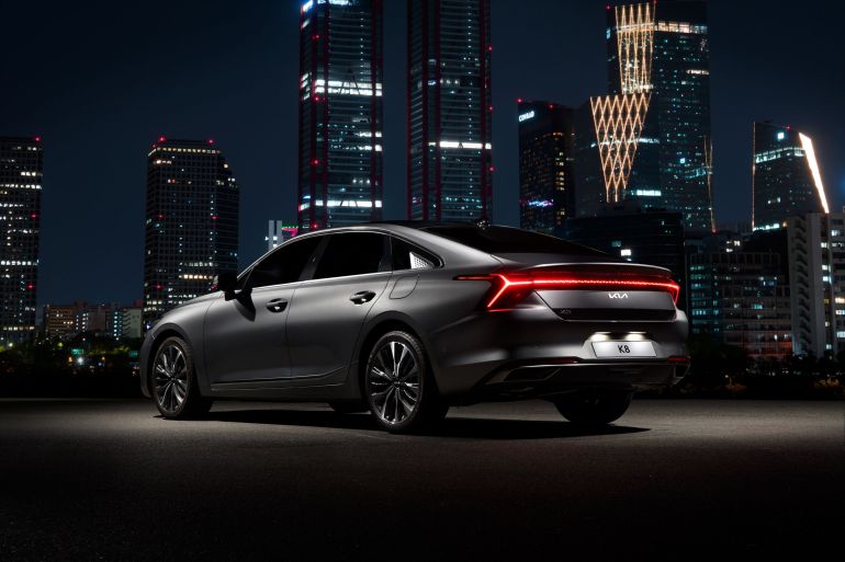 kwrya-1779805970 Stylish black car parked with illuminated Seoul skyline in the backdrop. Modern urban vibe.
