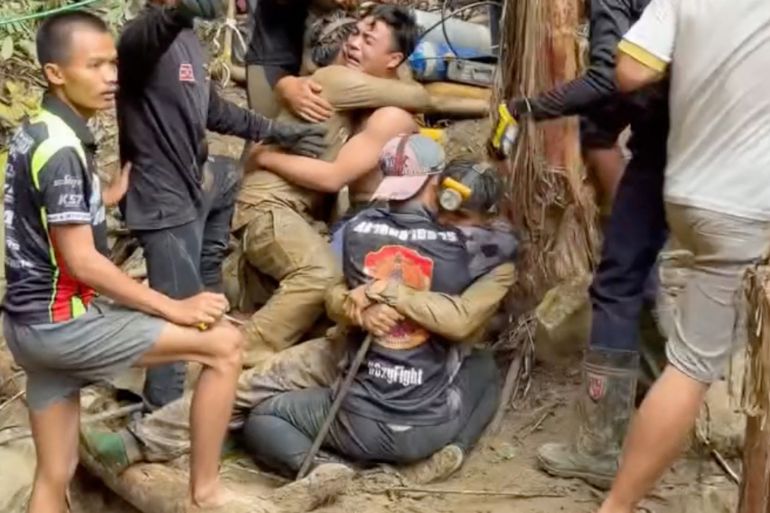 This screen grab made from handout video footage taken on May 30, 2026, and provided by Adisak Wongsoraya, shows two men (centre L and centre R, with headlamp) being hugged after they were rescued from a semi-submerged cave in Laos' central Xaysomboun province, northeast of the capital Vientiane. Four more men trapped in a semi-submerged Laos cave for 10 days were freed on May 30, rescuers said, after one was successfully brought to the surface a day earlier, but two remained missing. (Photo by Handout / Adisak Wongsoraya / AFP) / RESTRICTED TO EDITORIAL USE - MANDATORY CREDIT "AFP PHOTO/ Adisak Wongsoraya" - NO MARKETING NO ADVERTISING CAMPAIGNS - DISTRIBUTED AS A SERVICE TO CLIENTS - NO ARCHIVE