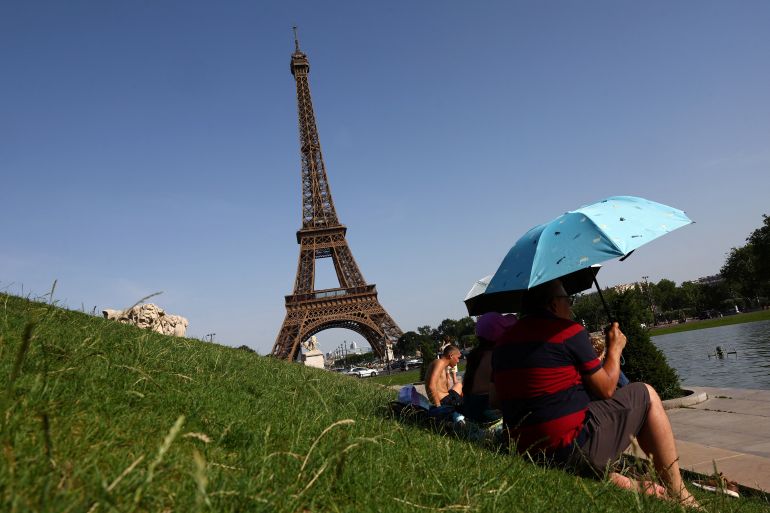 pic-8887746-1782245951 People use umbrellas to shade from the sun near the Trocadero fountain in front of the Eiffel Tower as temperatures rise in Paris during a heatwave affecting a large part of France, June 23, 2026. REUTERS/Abdul Saboor