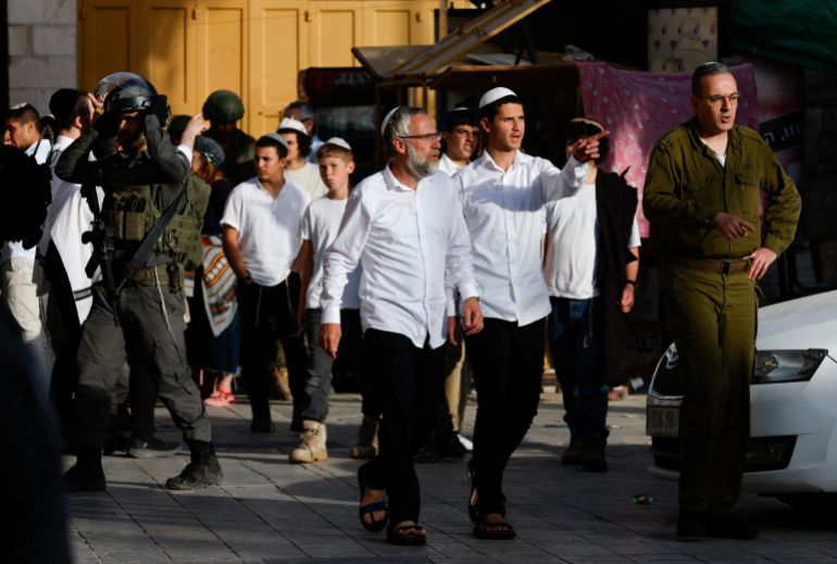 reuters_6a0223bf-1778525119-1 Israeli settlers walk next to soldiers during a weekly settlers' tour in Hebron, in the Israeli-occupied West Bank, May 2, 2026. REUTERS/Mussa Qawasma