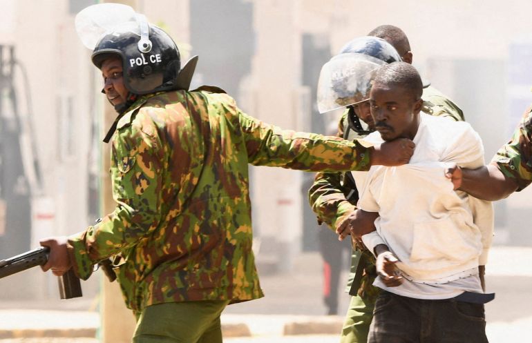 reuters_6a1eab47-1780394823 Riot police officers detain a demonstrator during protests against a U.S.-backed Ebola quarantine plan on the establishment of a 50-bed facility at a Kenyan air force base that was intended to host Americans exposed to Ebola, in Nanyuki town, in Laikipia County, Kenya June 1, 2026. REUTERS/John Muchucha