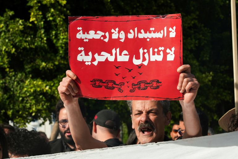 reuters_6a1f2e11-1780428305 A demonstrator displays a sign as Tunisians protest against President Kais Saied amid an economic and social crisis, in Tunis, Tunisia, May 16, 2026. REUTERS/Jihed Abidellaoui