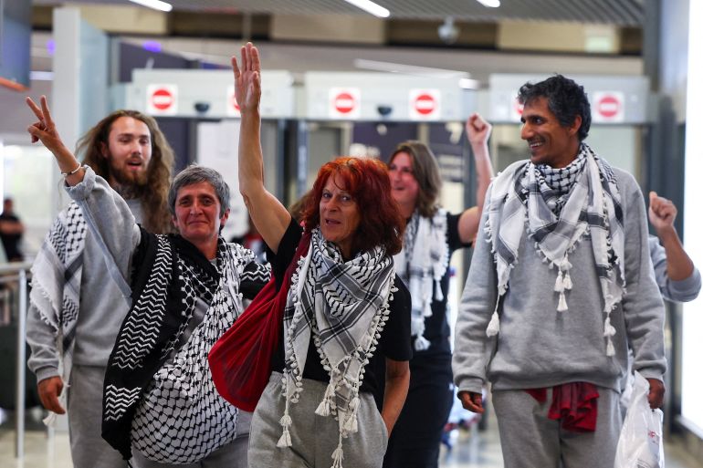 French activists from the Gaza-bound Global Sumud Flotilla, detained by Israeli forces after their vessels were intercepted in international waters in the Mediterranean, gesture upon arrival at Charles de Gaulle Airport, in Roissy-en-France, near Paris, France May 22, 2026. REUTERS/Abdul Saboor