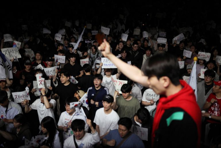 reuters_6a251475-1780814965 A demonstrator raises his fist as people surround a vote-counting centre to protest a controversy over a shortage of ballot papers that disrupted voting in the local election and to call for a rerun of the election, in Seoul, South Korea, June 6, 2026. REUTERS/Kim Hong-Ji