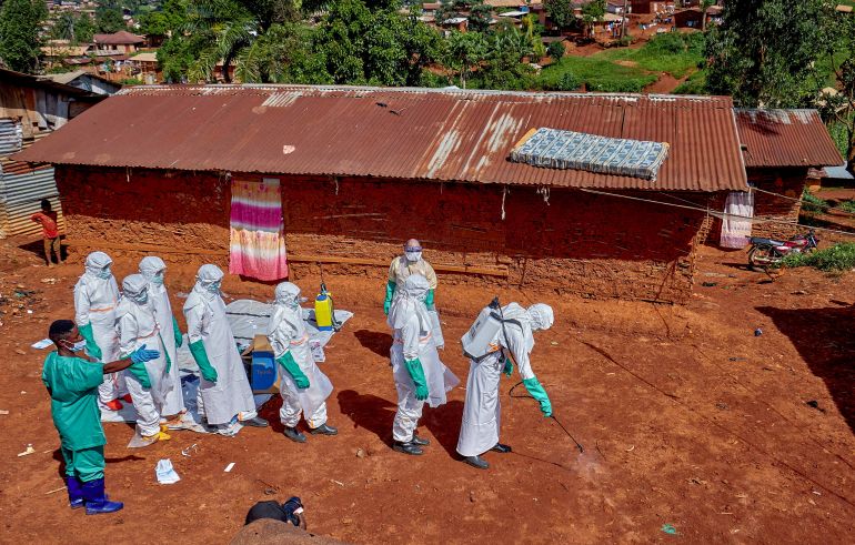 FILE PHOTO: Red Cross workers wearing personal protective equipment walk in a formation as they disinfect the ground outside the house of an unidentified man who died of Ebola, before retrieving his body, as aid agencies intensify efforts to contain a new Ebola outbreak involving the Bundibugyo strain, in Quartier Shuni 1, a residential sector in Mongbwalu, Djugu Territory of Ituri province, Democratic Republic of Congo, May 24, 2026. REUTERS/Gradel Muyisa Mumbere/File Photo